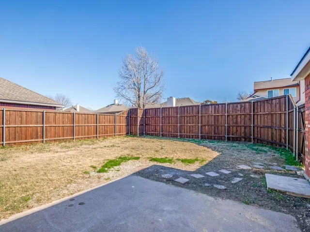 a view of a backyard with wooden fence