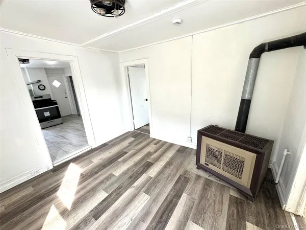 a view of a hallway to a house with wooden floor and furniture