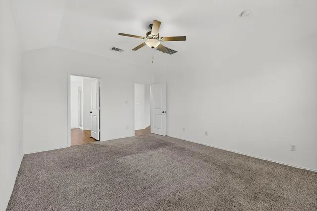 a view of an empty room with a ceiling fan