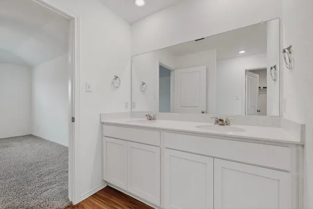 a bathroom with double sink and a mirror