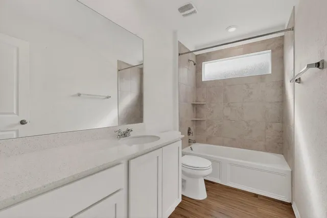 a bathroom with a granite countertop sink a toilet and shower