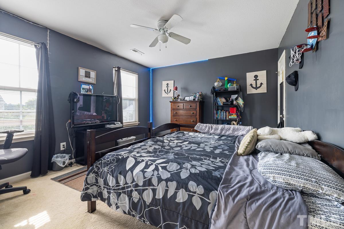 4818 Kitledge Drive Raleigh, NC 27610 - Photo 20 of 23 a bedroom with a bed and dresser with window