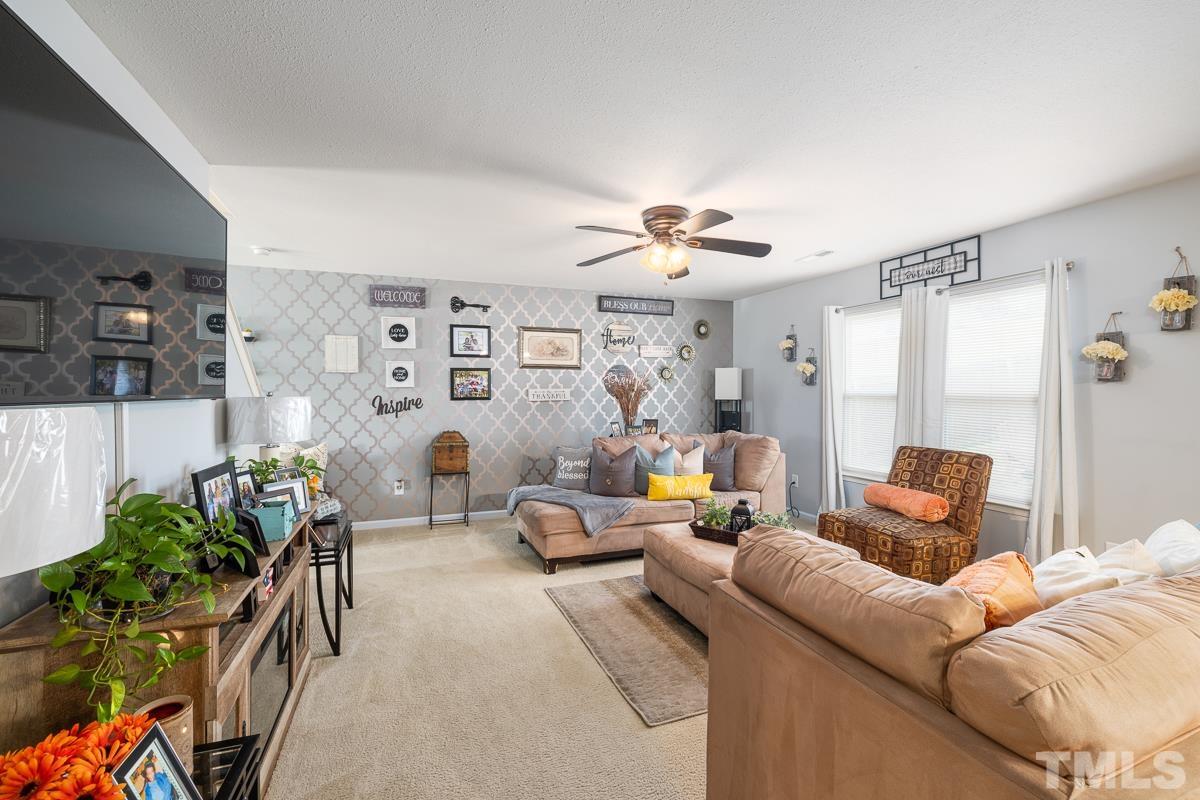 4818 Kitledge Drive Raleigh, NC 27610 - Photo 8 of 23 a living room with furniture and a chandelier