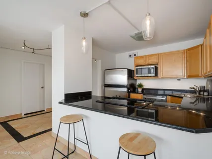 a kitchen with granite countertop a sink a counter space appliances and cabinets