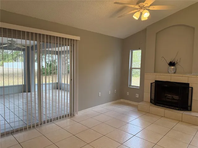 a view of an empty room with window and fire place