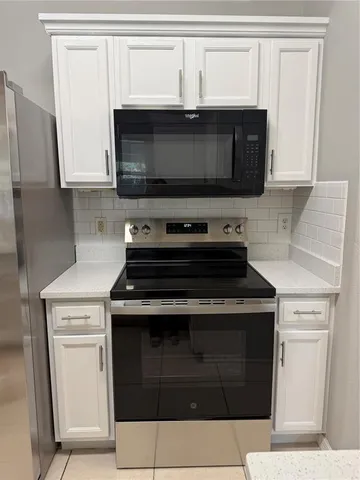 a stove top oven sitting inside of a kitchen