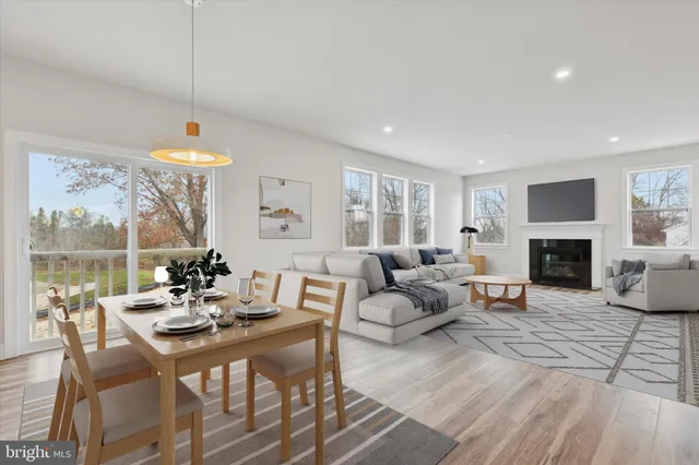 a living room with furniture a fireplace and a floor to ceiling window