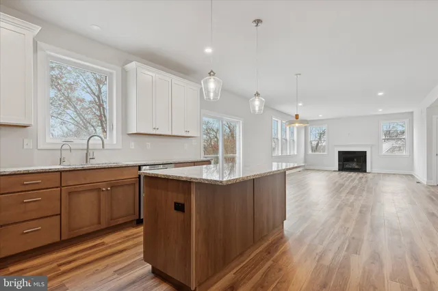 a kitchen with stainless steel appliances granite countertop a sink stove and wooden floor