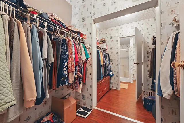a view of walk in closet with clothes and shoes