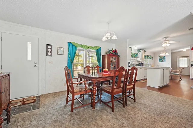 a view of a dining room with furniture and chandelier
