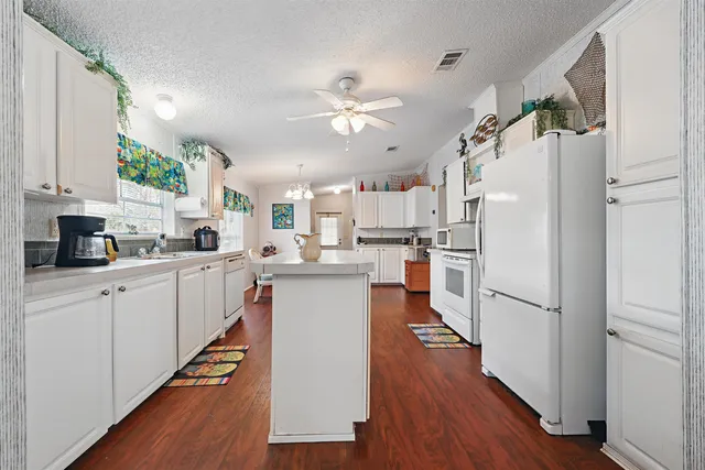 a kitchen with stainless steel appliances granite countertop a refrigerator a stove and a microwave