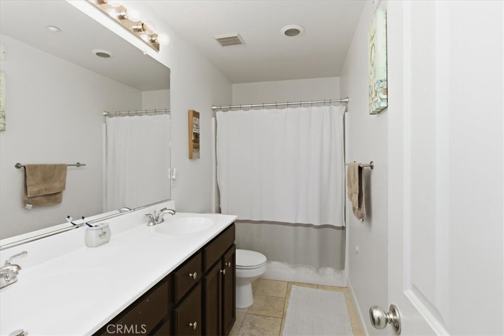 7353 Ellena West, Unit 70 Rancho Cucamonga, CA 91730 - Photo 25 of 40 a bathroom with a double vanity sink toilet mirror and shower