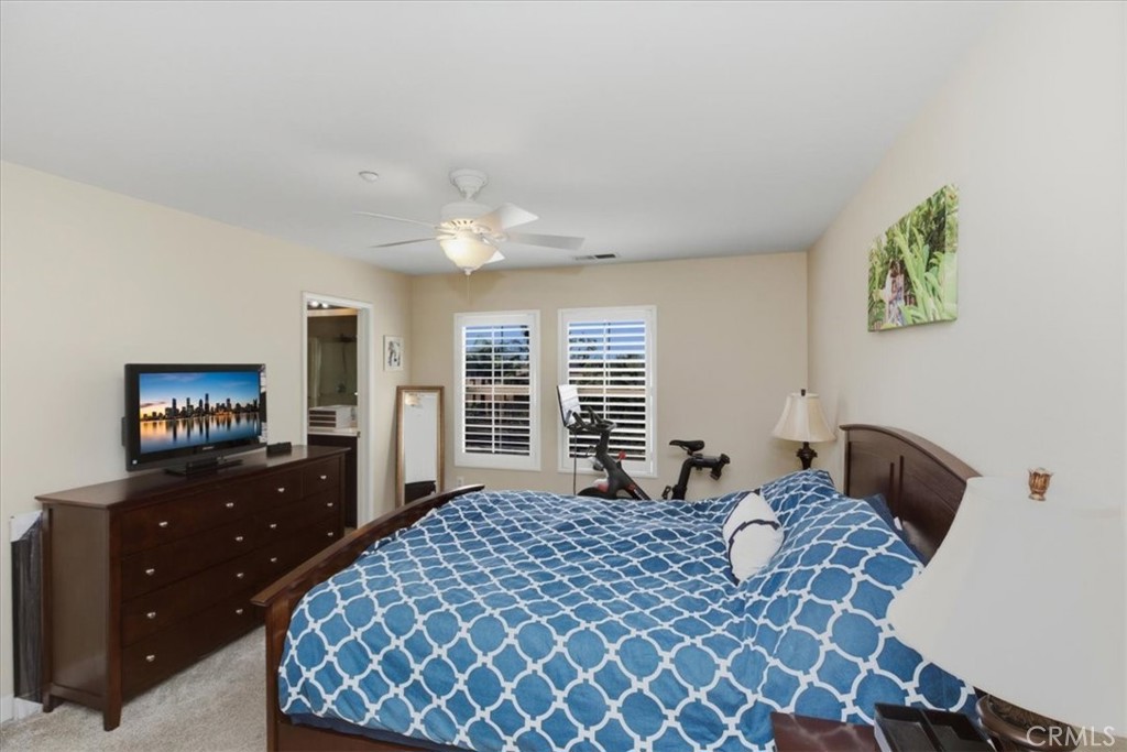 7353 Ellena West, Unit 70 Rancho Cucamonga, CA 91730 - Photo 26 of 40 a bedroom with a bed and a flat tv screen on dresser