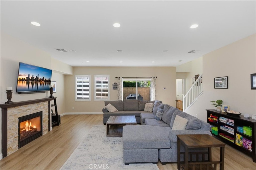 7353 Ellena West, Unit 70 Rancho Cucamonga, CA 91730 - Photo 6 of 40 a living room with furniture a fireplace and a flat screen tv