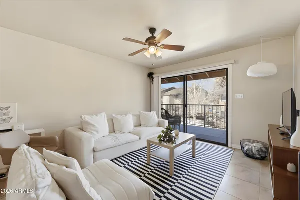 a living room with furniture a flat screen tv and a floor to ceiling window