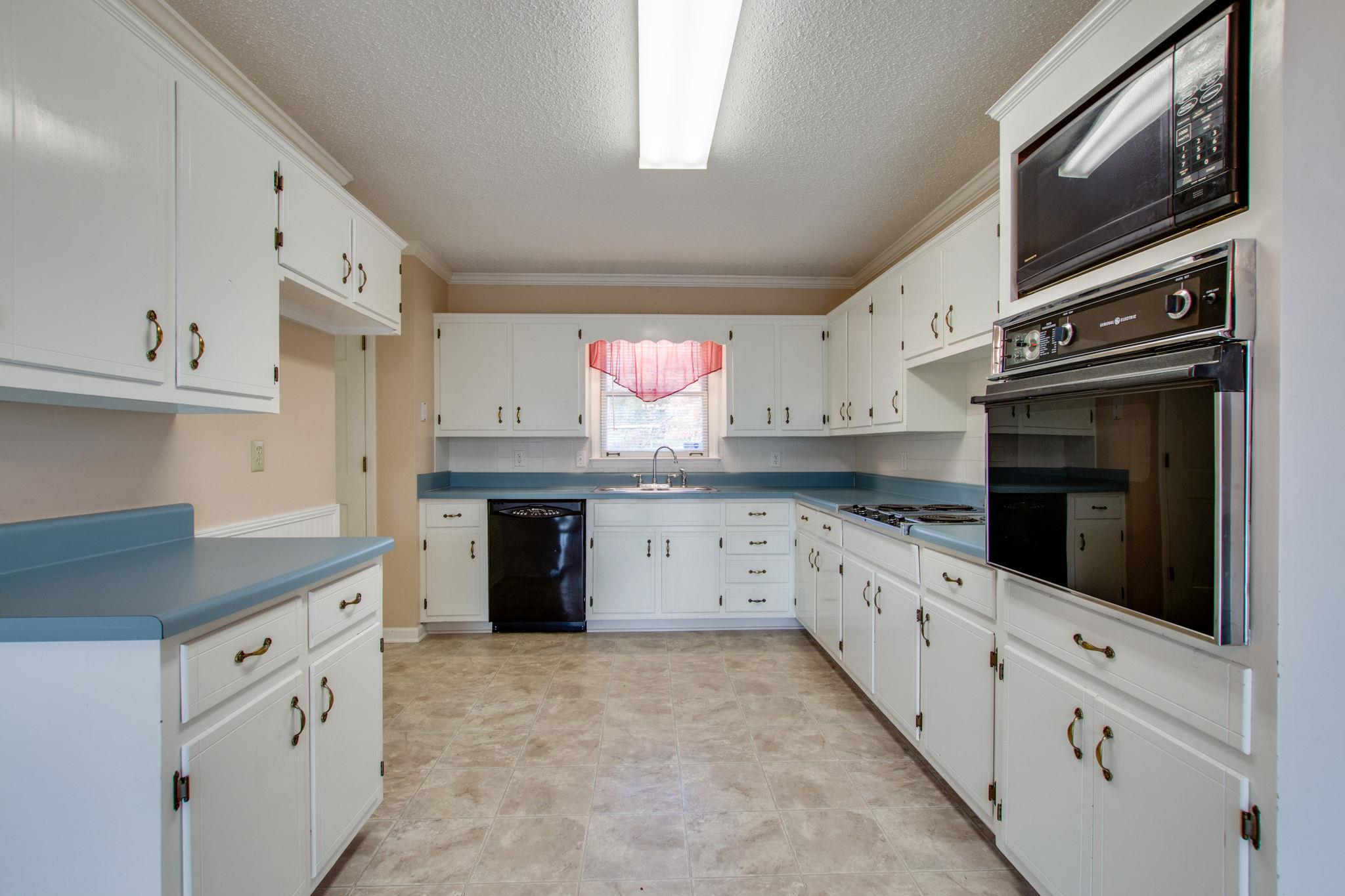 9464 Oregon Road Lascassas, TN 37085 - Photo 10 of 29 a kitchen with granite countertop a stove top oven sink and cabinets