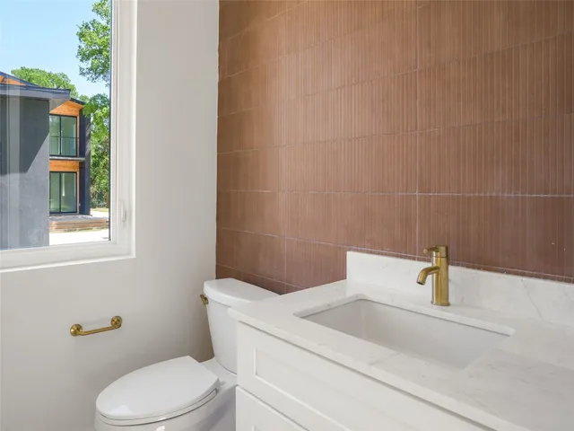 a bathroom with a toilet a sink and window