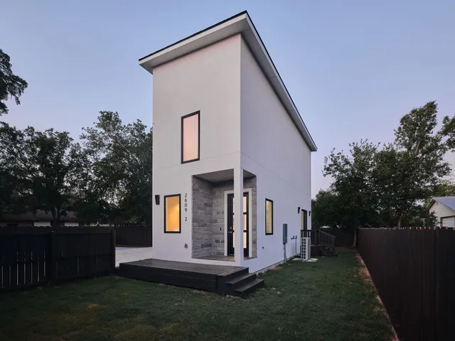a view of a house with backyard and trees