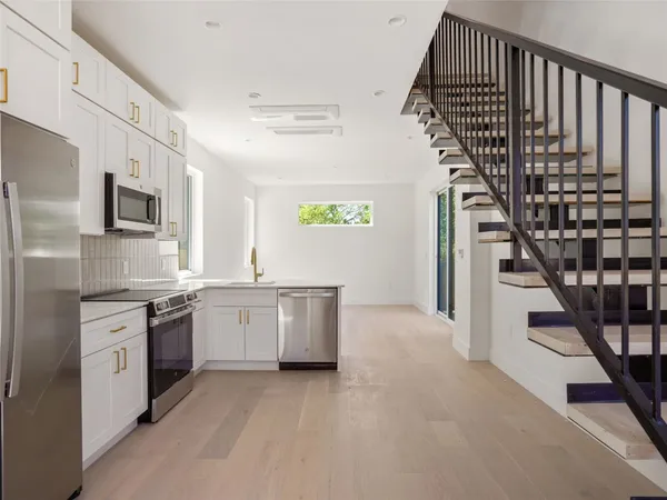 a kitchen with stainless steel appliances granite countertop a refrigerator and a sink
