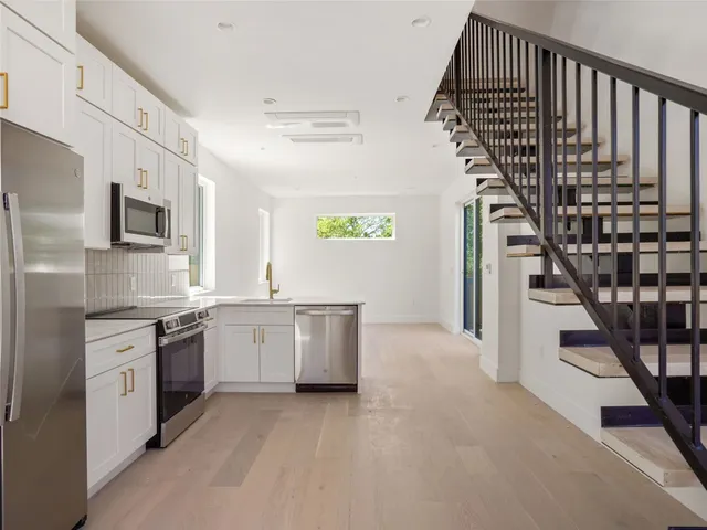 a kitchen with stainless steel appliances granite countertop a refrigerator and a sink