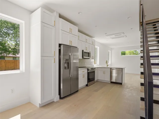 a kitchen with stainless steel appliances a refrigerator sink and stove