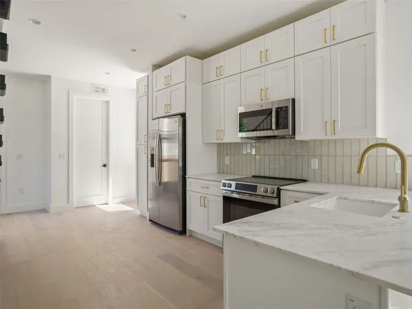a kitchen with a stove a refrigerator and a sink