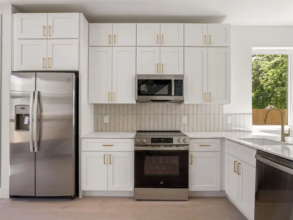 a kitchen with white cabinets and stainless steel appliances