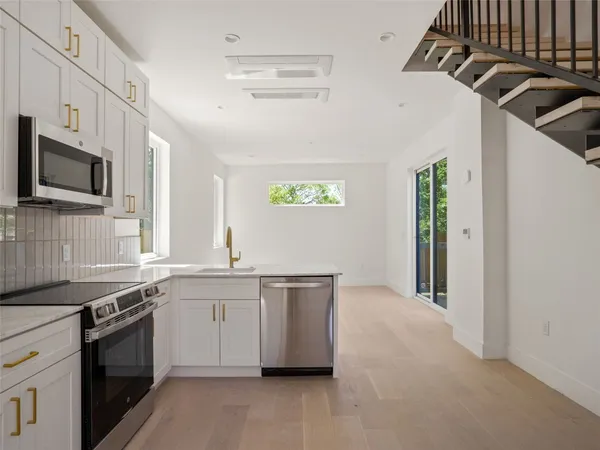 a kitchen with stainless steel appliances granite countertop a sink and a stove