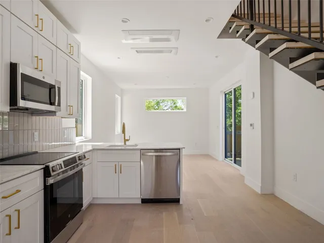 a kitchen with stainless steel appliances granite countertop a sink and a stove