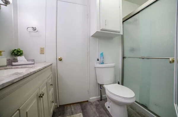 a bathroom with a granite countertop sink toilet and shower