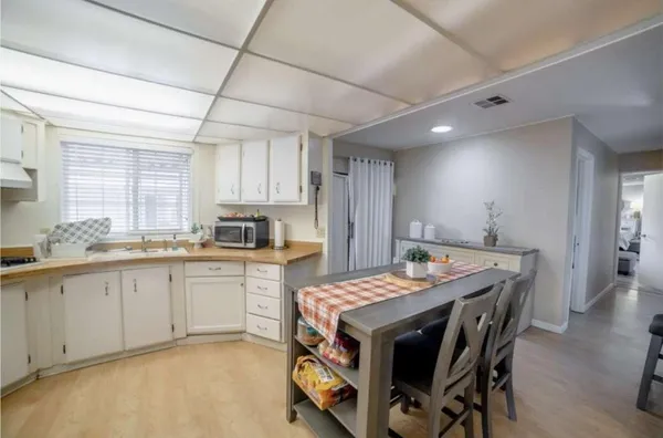 a kitchen with granite countertop a table chairs sink and cabinets