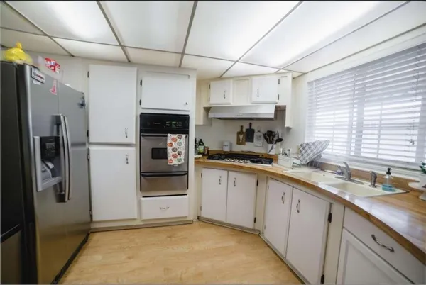 a kitchen with stainless steel appliances granite countertop a refrigerator and a sink