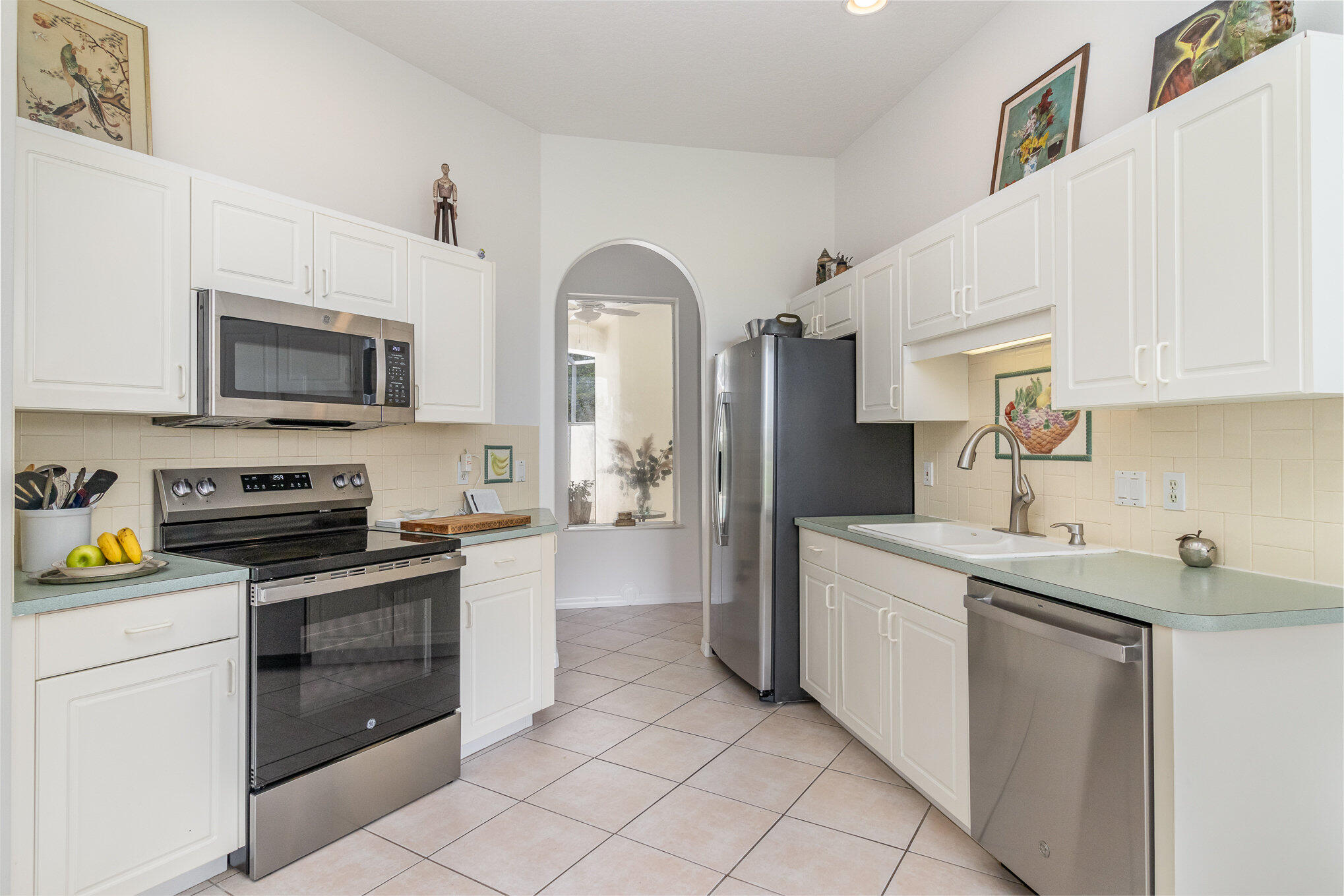 7951 Daventry Drive Melbourne, FL 32940 - Photo 3 of 46 a kitchen with stainless steel appliances a stove sink microwave and cabinets
