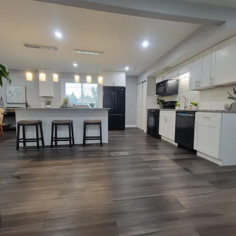 a large white kitchen with lots of counter space a sink and appliances
