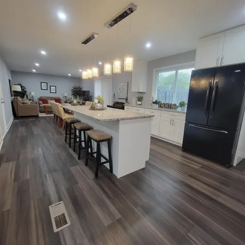 a kitchen with stainless steel appliances a dining table chairs and wooden floor