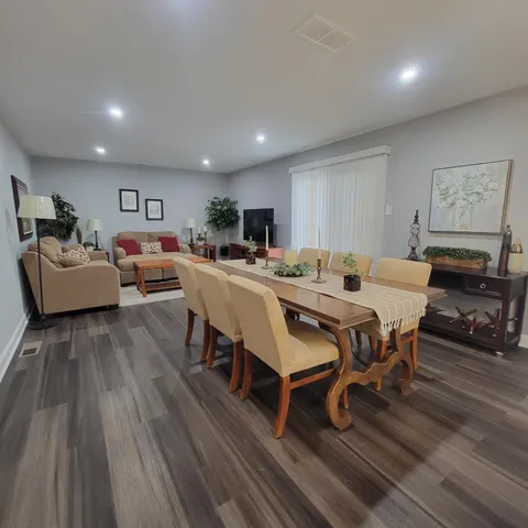 a view of a dining room with furniture wooden floor and chandelier