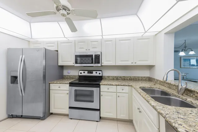 a kitchen with stainless steel appliances granite countertop a sink a stove and refrigerator