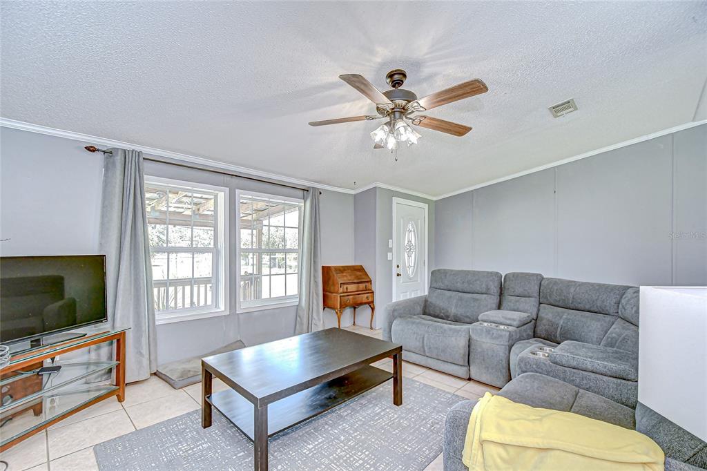 43650 County Road 54 East Kathleen, FL 33849 - Photo 11 of 72 a living room with furniture a flat screen tv and a window