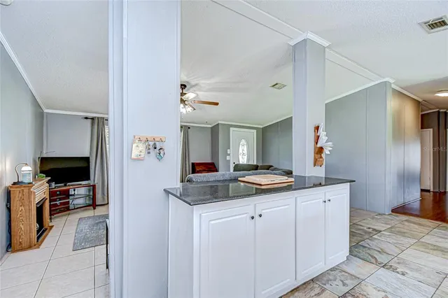 a bedroom with a bed a chandelier and a dresser