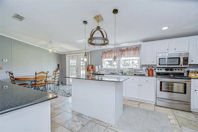a bathroom with a granite countertop double vanity sink a mirror and a bathtub