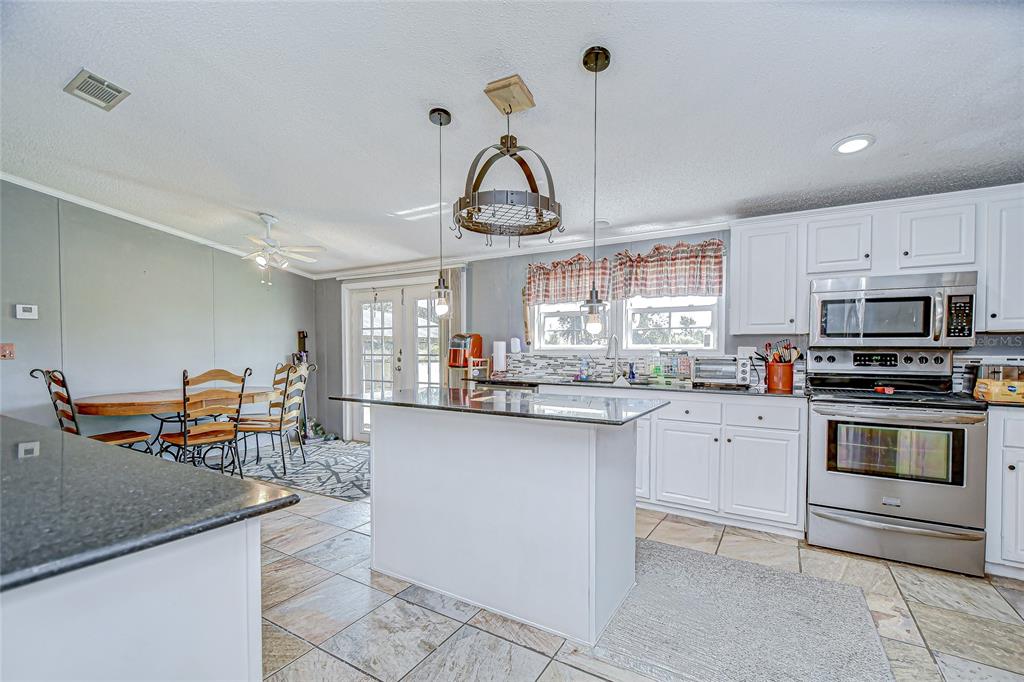 43650 County Road 54 East Kathleen, FL 33849 - Photo 17 of 72 a kitchen with stainless steel appliances granite countertop a sink and cabinets