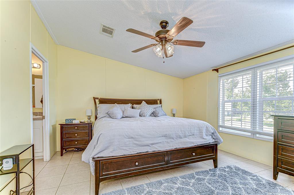 43650 County Road 54 East Kathleen, FL 33849 - Photo 21 of 72 a bedroom with a bed a chandelier and a dresser