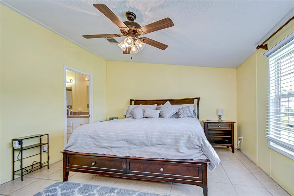 43650 County Road 54 East Kathleen, FL 33849 - Photo 22 of 72 a bedroom with a bed and a chandelier