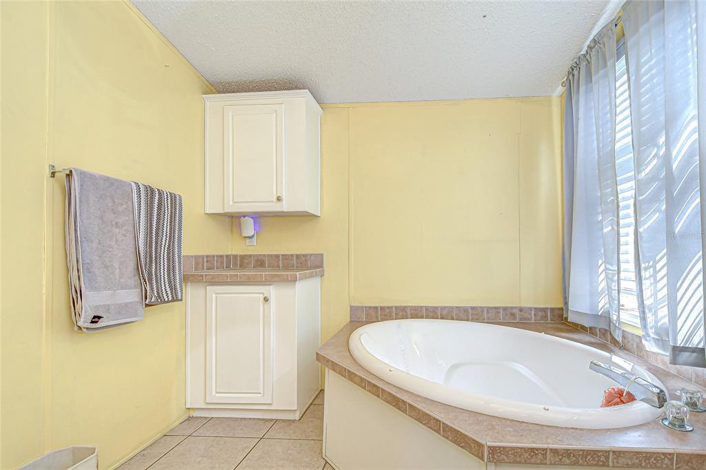 43650 County Road 54 East Kathleen, FL 33849 - Photo 25 of 72 a bathroom with a granite countertop sink and a mirror