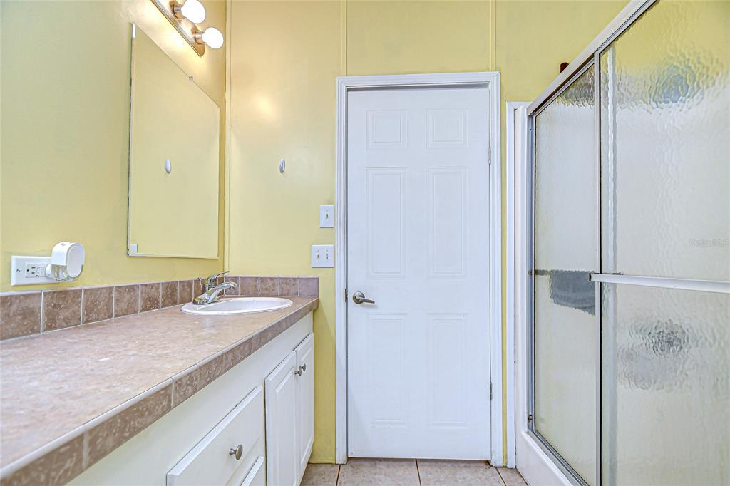 43650 County Road 54 East Kathleen, FL 33849 - Photo 27 of 72 a bathroom with a granite countertop sink and a mirror