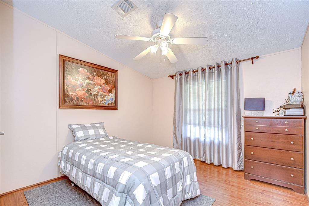 43650 County Road 54 East Kathleen, FL 33849 - Photo 28 of 72 a bedroom with a bed and a chandelier