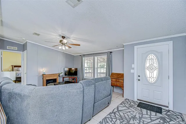 a living room with furniture a flat screen tv and a window