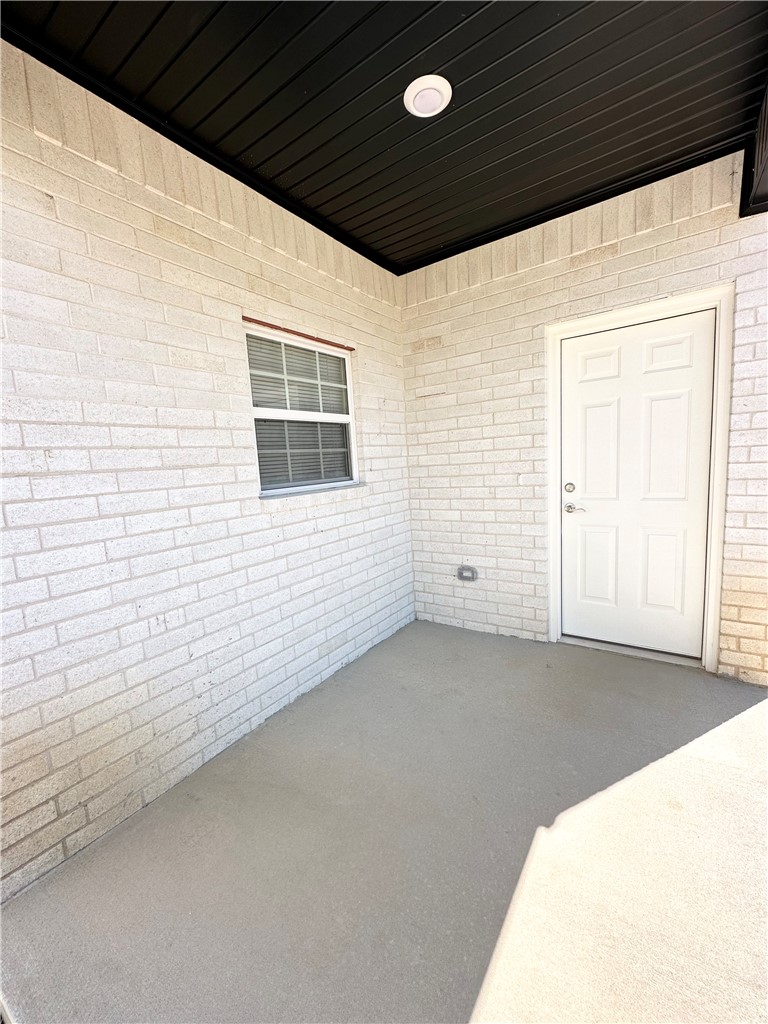 959 South Rupple Road, Unit 4 Fayetteville, AR 72704 - Photo 20 of 25 This property features a covered patio with a smooth concrete floor and brick walls