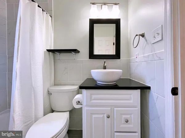 a bathroom with a granite countertop toilet sink and mirror