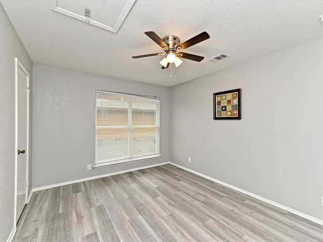 a view of an empty room with a window and a ceiling fan